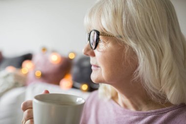 Üst düzey Bayan fincan çay uzağa bakarak holding