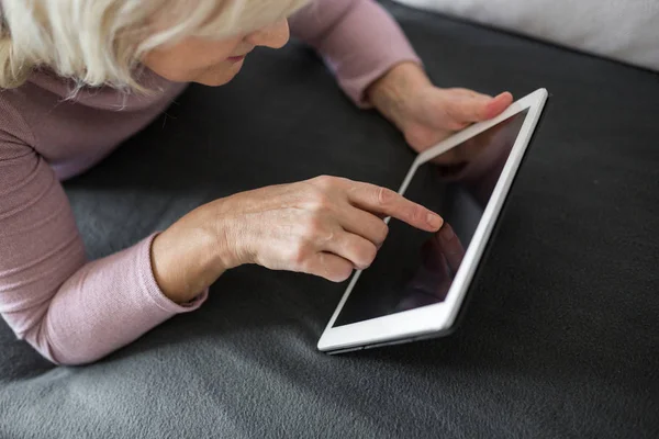 Señora mayor utilizando la pantalla táctil tableta — Foto de Stock