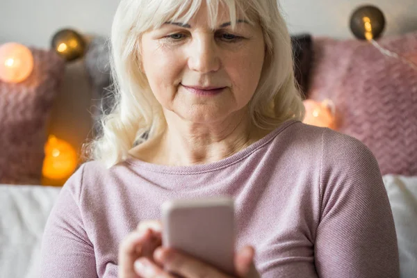 Feliz señora mayor usando mensajes de texto móviles — Foto de Stock