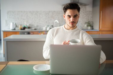 Genç adam evde defter üzerinde çalışan