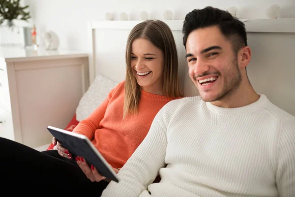 Gelukkige paar zittend op bed met behulp van Tablet PC — Stockfoto