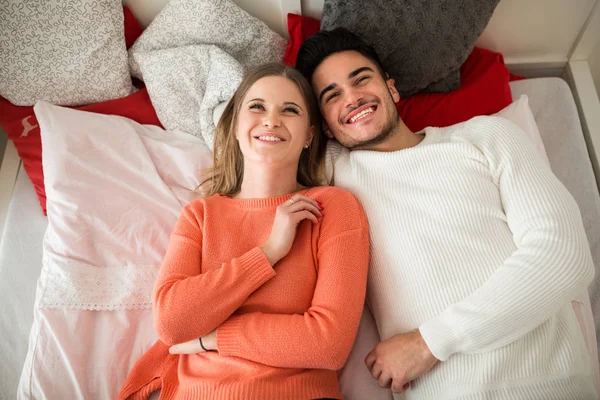 Šťastný pár ležící na posteli společně smát — Stock fotografie