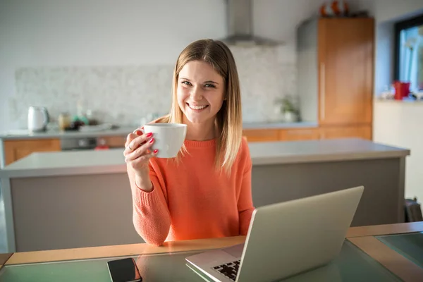 Młoda kobieta z cop kawy za pomocą laptopa uśmiechający się — Zdjęcie stockowe