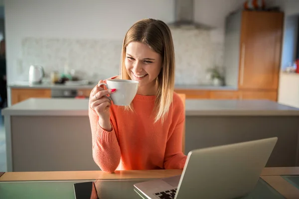 Szczęśliwa kobieta za pomocą laptopa picie kawy — Zdjęcie stockowe