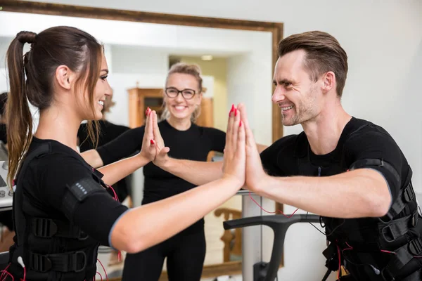 Homem feliz e mulher treinando juntos exercícios ems — Fotografia de Stock