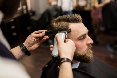 Genç adam saç kuaför dükkanında traş olması