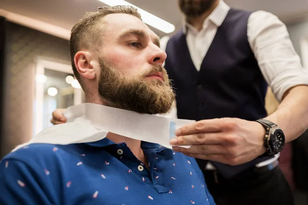 Peluquero poniendo cinta de peluquería alrededor del cuello del cliente — Foto de Stock