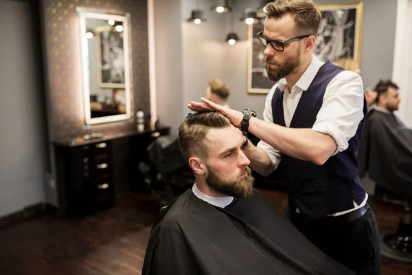 Фокусный парикмахер работает на волосы клиента — стоковое фото