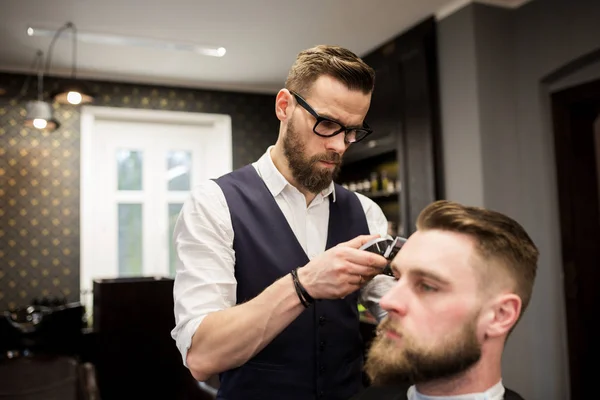 Peluquero ocupado afeitar el pelo del cliente — Foto de Stock