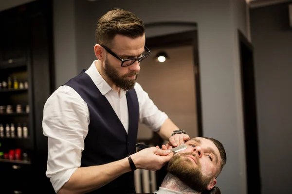 Holič zákazníkovi holení s holicí strojek — Stock fotografie
