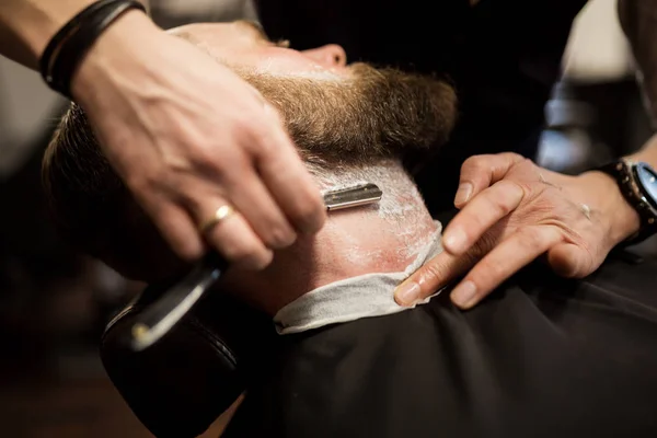 Бородатого мужчину брили бритвой. — стоковое фото