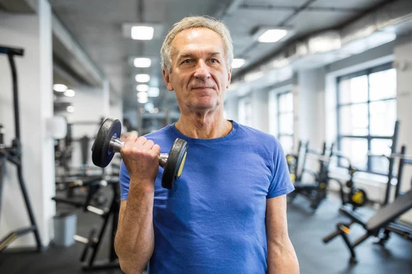 Sterk senior mann som holder dumbbell i gymsalen – stockfoto