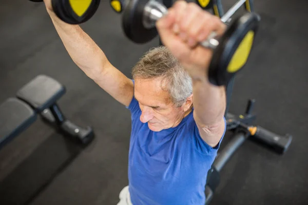 Senior mann løfter vekter på hammerstyrkemaskin – stockfoto