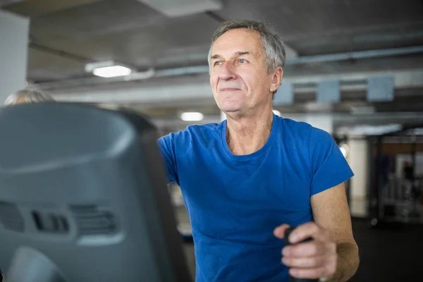 Feliz hombre mayor haciendo ejercicio en escalera stepper en el gimnasio — Foto de Stock