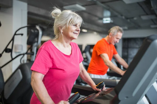 Glad senior dametrening på tredemølle i gymsalen – stockfoto
