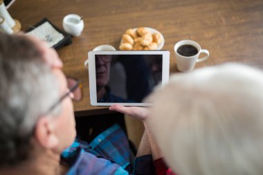 Üst düzey insanlar holding tablet mutfak masasında