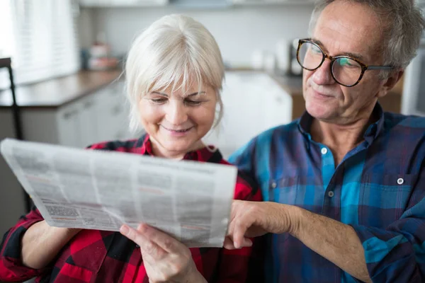 Pareja mayor leyendo el periódico juntos — Foto de Stock