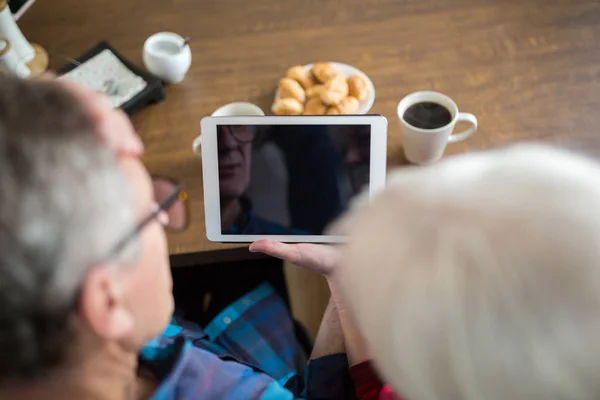 Personas mayores sosteniendo la tableta en la mesa de cocina — Foto de Stock