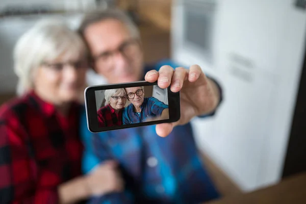 Pareja mayor tomando selfie por móvil — Foto de Stock