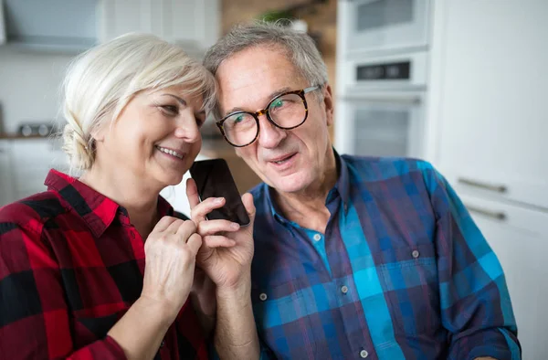 Feliz pareja mayor teniendo conversación telefónica — Foto de Stock
