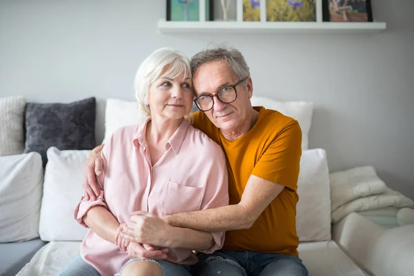 Gelukkig senior huwelijk omarmen samen op bank — Stockfoto