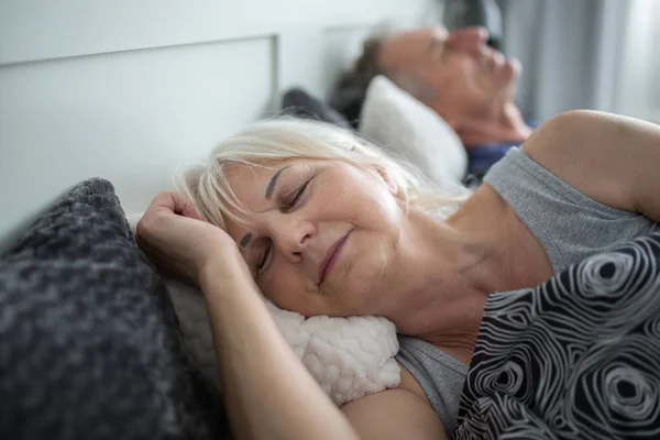 Starszy pani spanie w komfortowe łóżko z mężem — Zdjęcie stockowe
