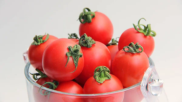 新鲜的西红柿放在一个碗里 用白色隔开 红色的樱桃西红柿在透明的盘子里 白色背景特写 春天做沙拉用的新鲜小西红柿 — 图库照片