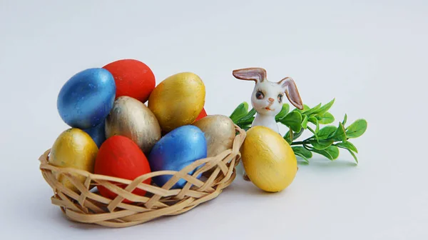 Coloridos Huevos Pascua Una Canasta Mimbre Conejo Pascua Sobre Fondo — Foto de Stock