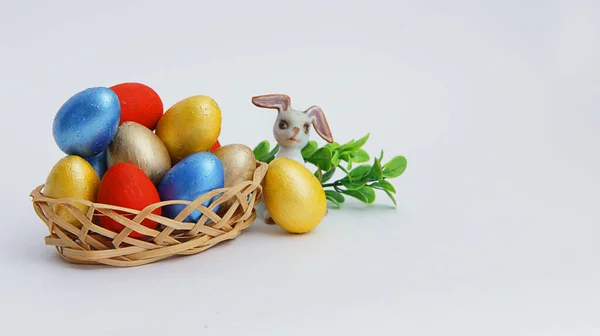 Coloridos Huevos Pascua Una Canasta Mimbre Conejo Pascua Sobre Fondo — Foto de Stock