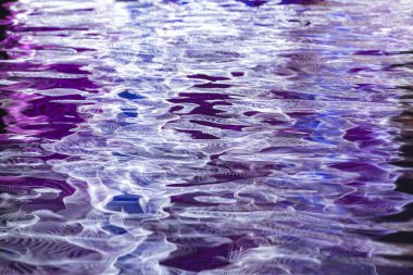 Sonsuzluk aynaları sudaki dalga desenlerine yansıyor.