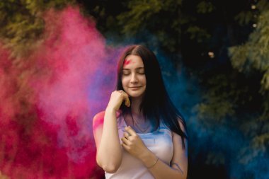 Onun yanında patlayan renkli toz ile gülümseyen kadın