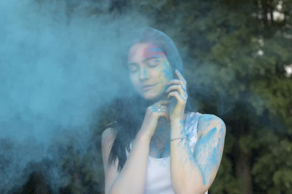 Brunette model posing with color powder falling on her — Stock Photo, Image