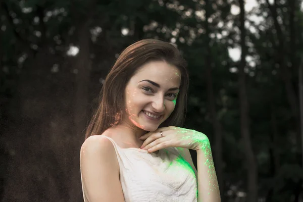 Femme brune souriante avec de la poudre Holi sur le visage — Photo