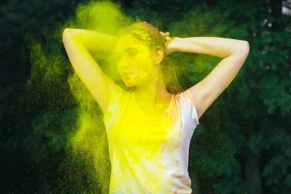 Beautiful young woman standing in a cloud of dry paint — Stock Photo, Image