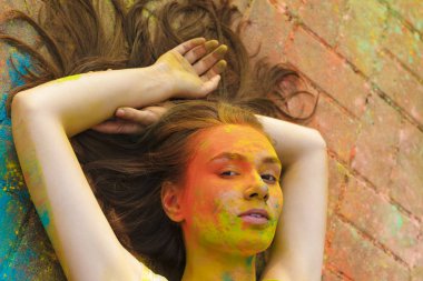 Genç kadının yüzünde renkli toz ile poz