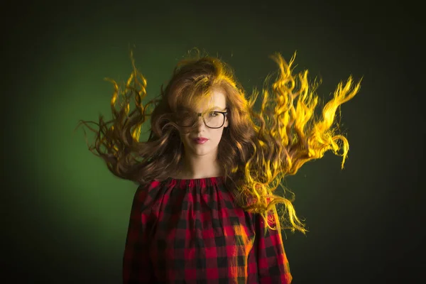 Beautiful young model with hair in motion wearing glasses