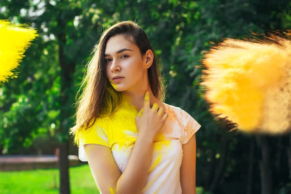 Genç kadın Portakal tozu Holi ile poz 