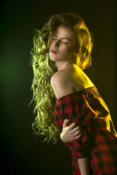 长长的卷发，在彩色灯光的性感女人 — 图库照片