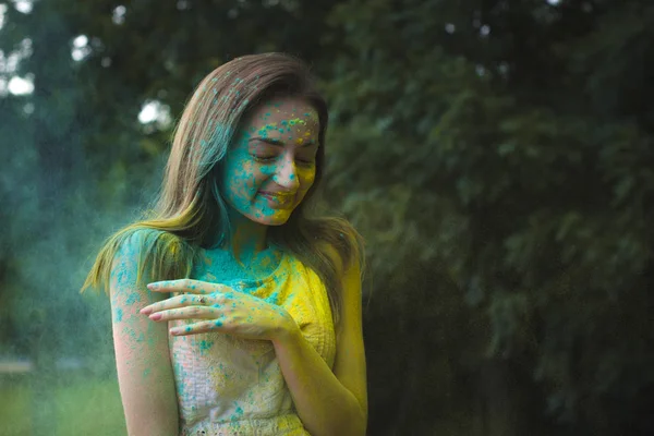 Härlig ung kvinna med pulver Holi på hennes ansikte — Stockfoto