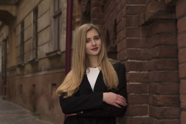 Gülümseyen yakınındaki duvara sıcak montlu sarışın kadın