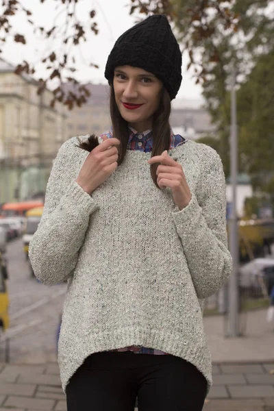 Ευτυχισμένος νεαρή γυναίκα σε ένα ζεστό πουλόβερ και καπάκι — Φωτογραφία Αρχείου