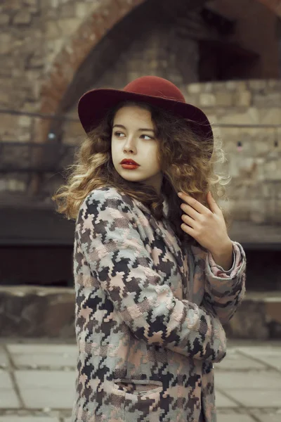 Modelo glamouroso em chapéu vermelho e casaco na rua — Fotografia de Stock