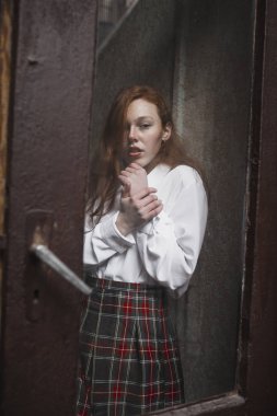 Eski cam kapının arkasında çiller ile genç redhead modeli