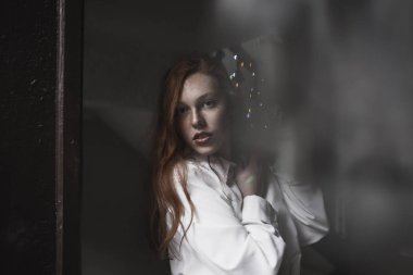 Güzel genç model cam kapının arkasında çiller ile