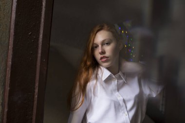 Karanlık pasajda çilli güzel kızıl saçlı modeli