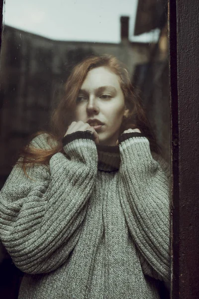 Привлекательная молодая модель с веснушками за стеклянной дверью — стоковое фото