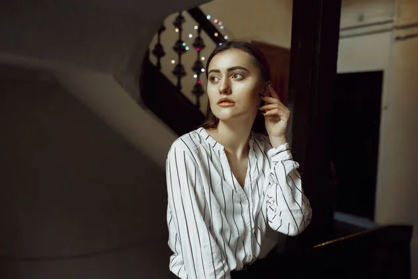 Glamouröse junge brünette Dame posiert im dunklen Zimmer — Stockfoto