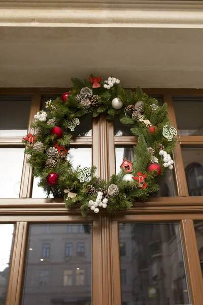 Ahşap bir kapı cam ile asılı Noel çelenk