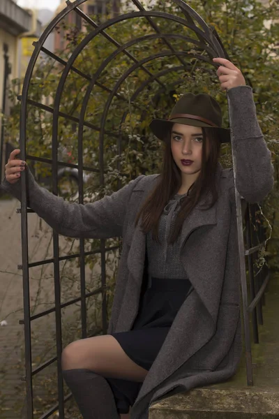 Modieuze brunette vrouw in hoed en jas — Stockfoto