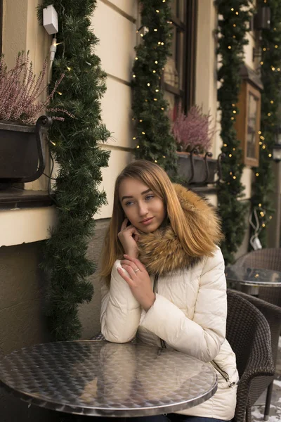 Прекрасна жінка сидить у кафе з розмитим фоном світла — стокове фото